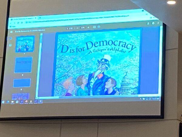 Slide presentation of the supplemental reader “D is for Democracy” addressed further public hearing regarding CRT content in “instructional materials.” (Patricia Tolson/The Epoch Times)