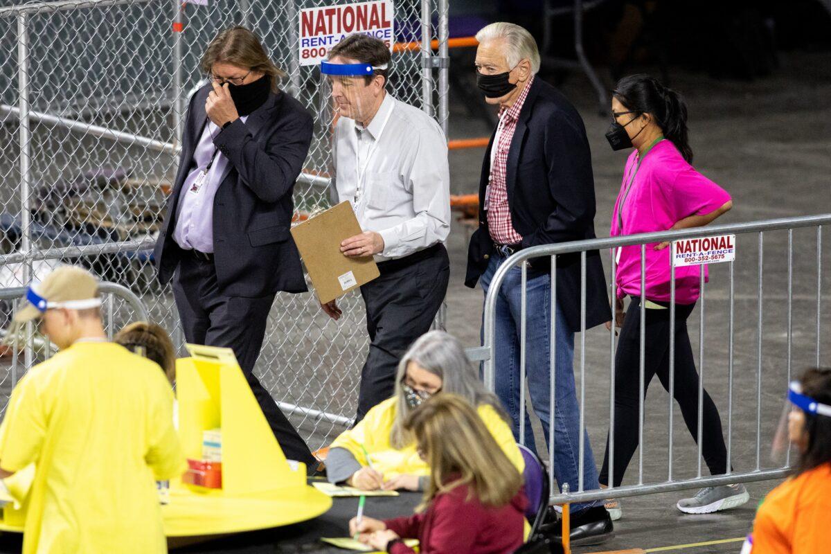 Former Secretary of State Ken Bennett (second from left) moves ballots during an election audit at Veterans Memorial Coliseum in Phoenix, Ariz., on May 1, 2021. (Courtney Pedroza/Getty Images)