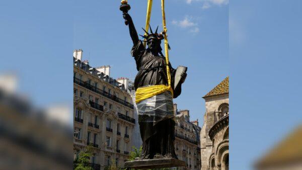 A 2.83-meter (9.3 foot) original replica of the Statue of Liberty is lifted by a crane from outside the Musee des Arts et Metiers in Paris, France, on June 7, 2021. (Noemie Olive/Reuters)