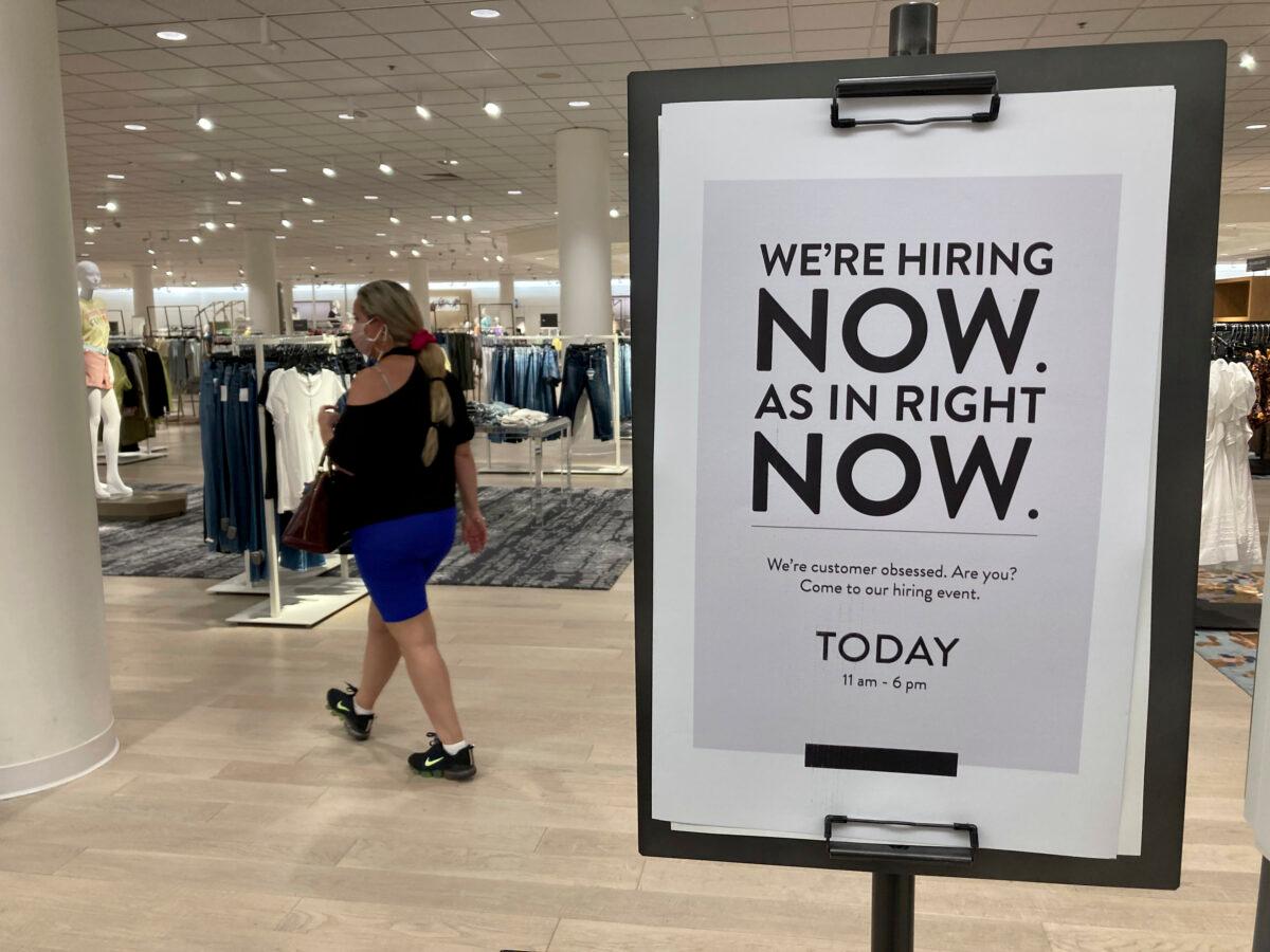 A customer walks behind a sign at a Nordstrom store seeking employees, in Coral Gables, Fla., on May 21, 2021. (Marta Lavandier/AP Photo)