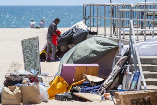 A homeless man sorts through his things in Venice Beach, Calif., on June 8, 2021. (John Fredricks/The Epoch Times)