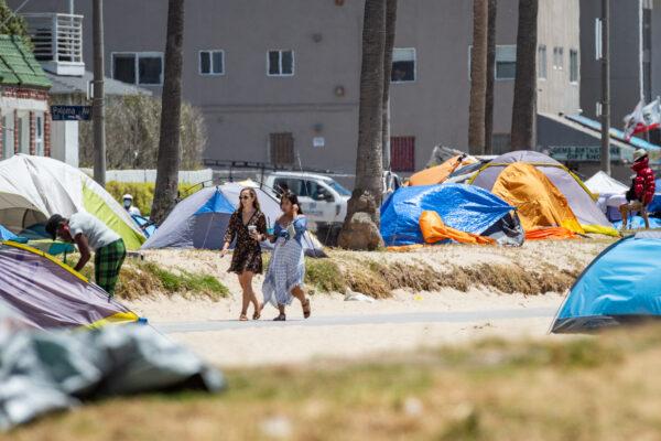 Women walk past homeless encampments in Venice Beach, Calif., on June 8, 2021. (John Fredricks/The Epoch Times)