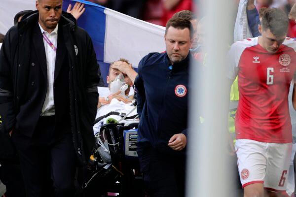 Paramedics using a stretcher to take out of the pitch Denmark's Christian Eriksen after he collapsed during the Euro 2020 soccer championship group B match between Denmark and Finland at Parken stadium in Copenhagen, Denmark, on June 12, 2021. (Friedemann Vogel/Pool via AP)