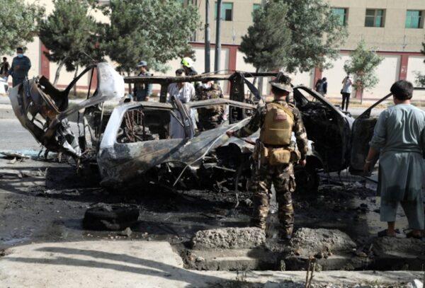 Afghan security forces inspect the wreckage of a passenger van after a blast in Kabul, Afghanistan on June 12, 2021. (Stringer via Reuters)