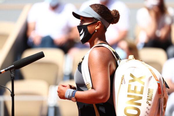 Naomi Osaka of Japan talks as she is interviewed on court after winning her First Round match against Patricia Maria Tig of Romania during Day One of the 2021 French Open at Roland Garros in Paris, France, on May 30, 2021. (Julian Finney/Getty Images)