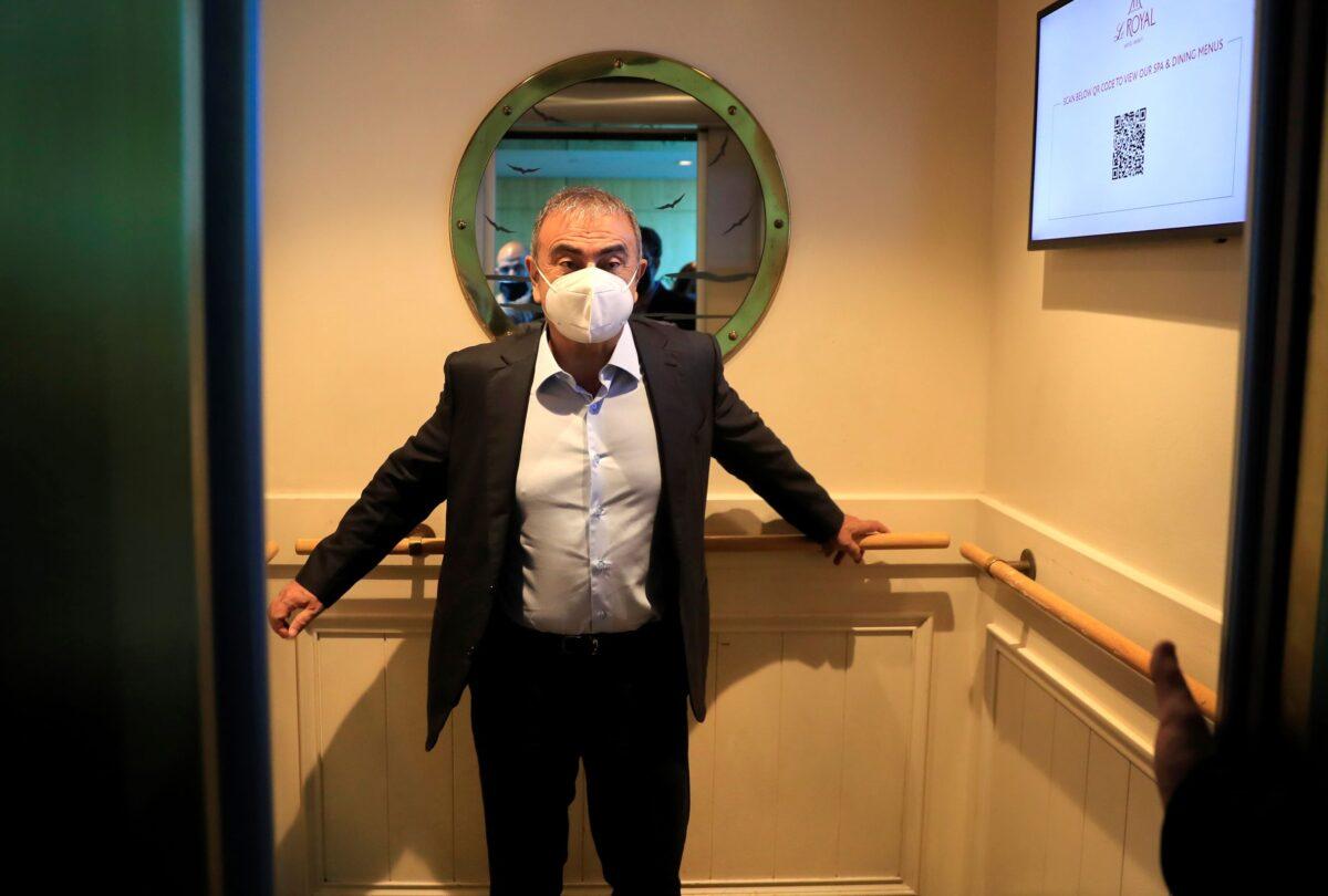 Fugitive ex-auto magnate Carlos Ghosn stands inside the elevator on his way to a media interview, in Dbayeh, north of Beirut, Lebanon, on May 25, 2021. (Hussein Malla/AP Photo)