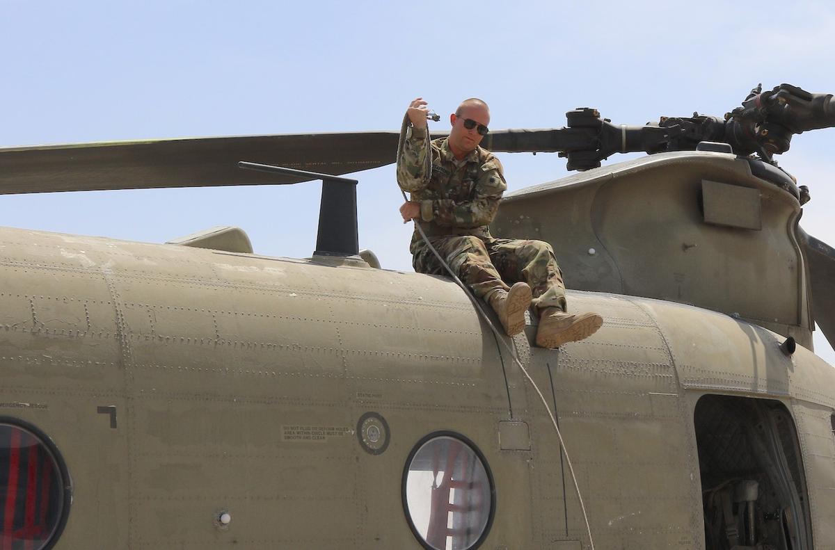 Staff Sgt. Brandon Stafford preps a Chinook helicopter for flight at Camp Buehring, Kuwait. (Courtesy of <a href="https://www.dvidshub.net/image/6639453/soldiers-shave-their-heads-support-battle-buddys-sister-who-recovering-cancer">Maj. Jason Sweeney</a>)