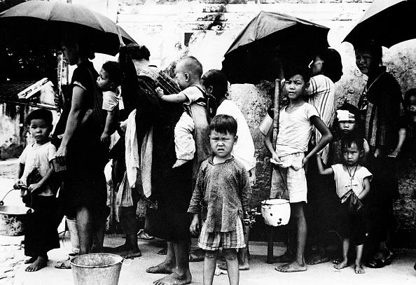 In May 1962, Chinese refugees stand in line for a meal. During the famine caused by "The Great Leap Forward" Chinese policy, between 140,000 and 200,000 people entered illegally into Hong Kong. (AFP via Getty Images)