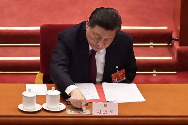 Chinese leader Xi Jinping votes on changes to Hong Kong's election system during the closing session of the National People's Congress at the Great Hall of the People in Beijing, China on March 11, 2021. (Nicolas Asfouri/AFP via Getty Images)