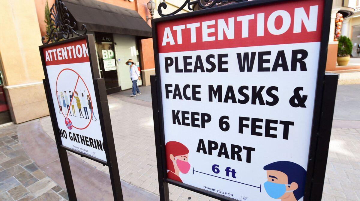 Signs reminding people of social distancing and wearing face masks remain at a mall in Calif., on June 14, 2021. (Frederic J. Brown/AFP via Getty Images)