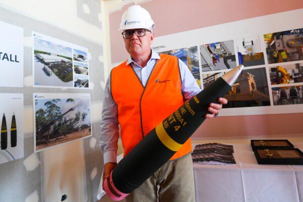 Australian Prime Minister Scott Morrison holds an ammunition shell during a visit to the Rheinmetall NIOA Munition factory in Maryborough, Queensland, Australia, on Jan. 21, 2021. (AAP Image/Lukas Coch)