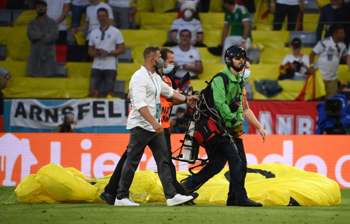 Paraglider walks on the pitch prior to the start of the Euro 2020 soccer championship group F match between Germany and France at the Allianz Arena stadium in Munich, on June 15, 2021. (Franck Fife/Pool via AP)