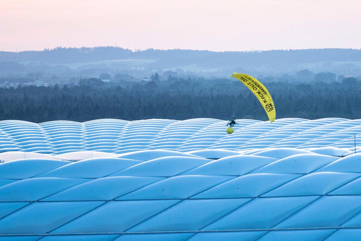 A man in a Greenpeace paraglider flies into the stadium prior to the Euro 2020 soccer championship group F match between France and Germany at the Allianz Arena stadium in Munich, Germany, on June 15, 2021. (Matthias Balk/DPA via AP)