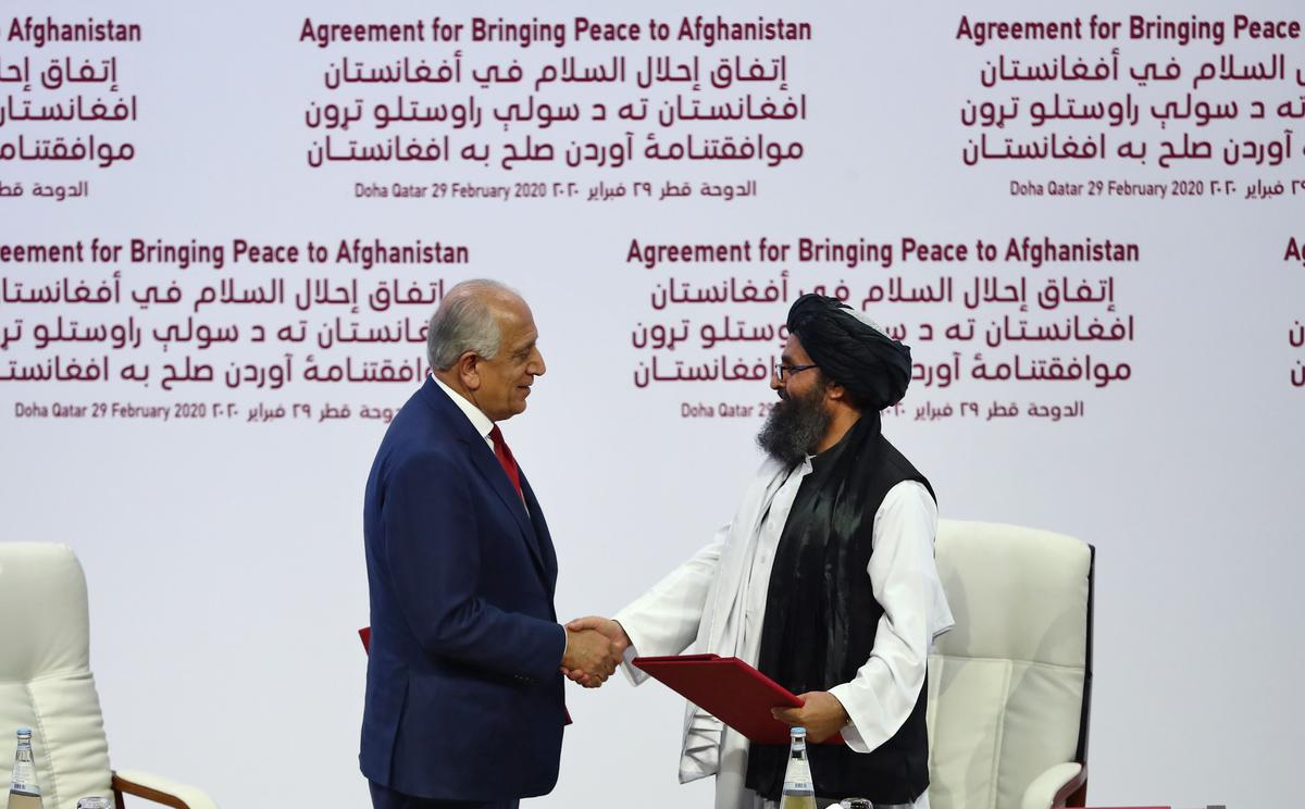 (L to R) U.S. Special Representative for Afghanistan Reconciliation Zalmay Khalilzad and Taliban co-founder Mullah Abdul Ghani Baradar shake hands after signing a peace agreement during a ceremony in Doha, Qatar, on Feb. 29, 2020. (Karim Jaafar/AFP via Getty Images)