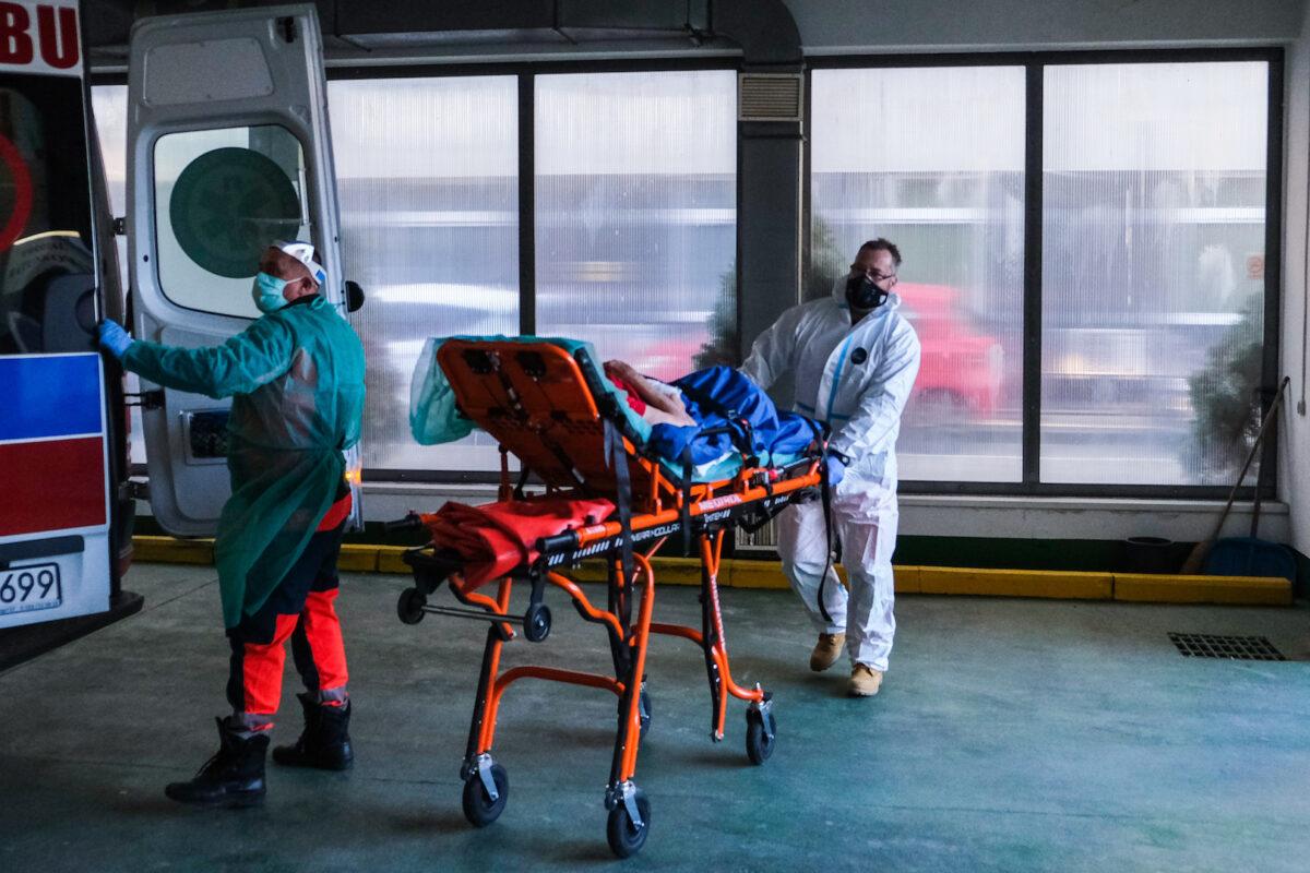 Paramedics wheel a stretcher with a patient showing COVID-19 symptoms from a nursery house in Bochnia, Poland, on Dec. 1, 2020. (Omar Marques/Getty Images)