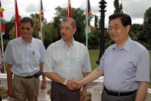 Former Chinese leader Hu Jintao (R) poses with Seychelles President James Michel (C) as Seychelles Secretary of State Alain Butler-Payette (L) watches at the island nation's capital, Victoria, on Feb. 10, 2007. (Stringer/AFP via Getty Images)