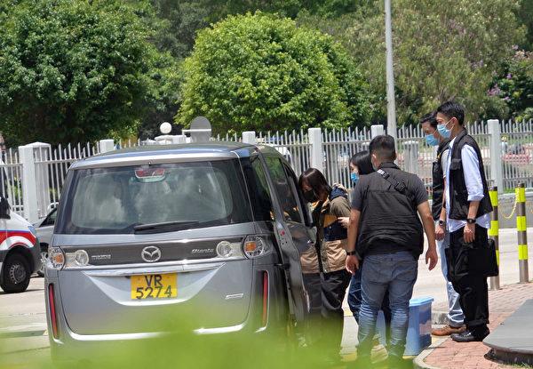 Apple Daily’s associate publisher Chan Pui-man was led to a car handcuffed from the Apple Daily headquarters in Hong Kong on June 17, 2021. (Adrian Yu/The Epoch Times)