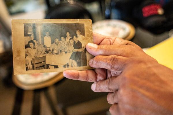 U.S. Marine veteran Dave Culmer holds an old photo featuring him (center) and military friends during the Korean War at his home in Culver City, Calif., on June 13, 2021. (John Fredricks/The Epoch Times)