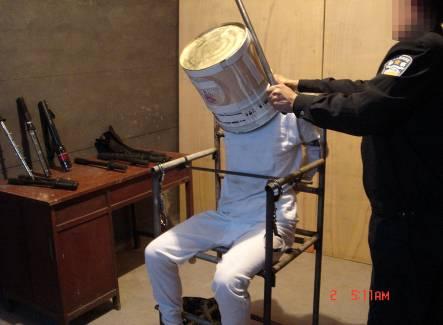 Reenactment of beating on a metal bucket. (<a href="https://en.minghui.org/">Minghui.org</a>)