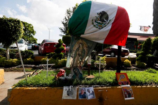 Photos of people who died in a metro collapse hang alongside a Mexican flag and images of Our Lady of Guadalupe, at the site of the now missing metro section in Mexico City, on June 16, 2021. (Fernando Llano/AP Photo)