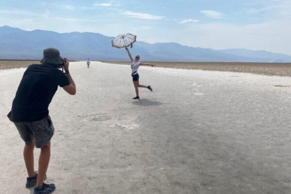Lana, 43, a tourist from North Carolina, poses for a picture holding an umbrella at Badwater Basin, the lowest point of North America below sea level in Death Valley, Calif., on June 16, 2021. (Norma Galeana/Reuters)