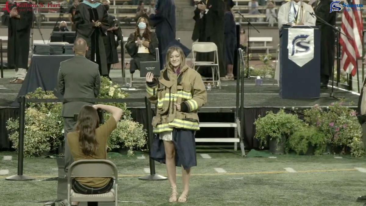 Joslyn Carlon receiving her diploma in her late father's firefighting jacket. (Courtesy of WSH Graduations/YouTube)
