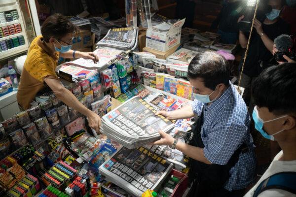 A man buys multiple copies of the latest Apple Daily newspaper in Hong Kong on June 18, 2021. (Anthony Kwan/Getty Images)