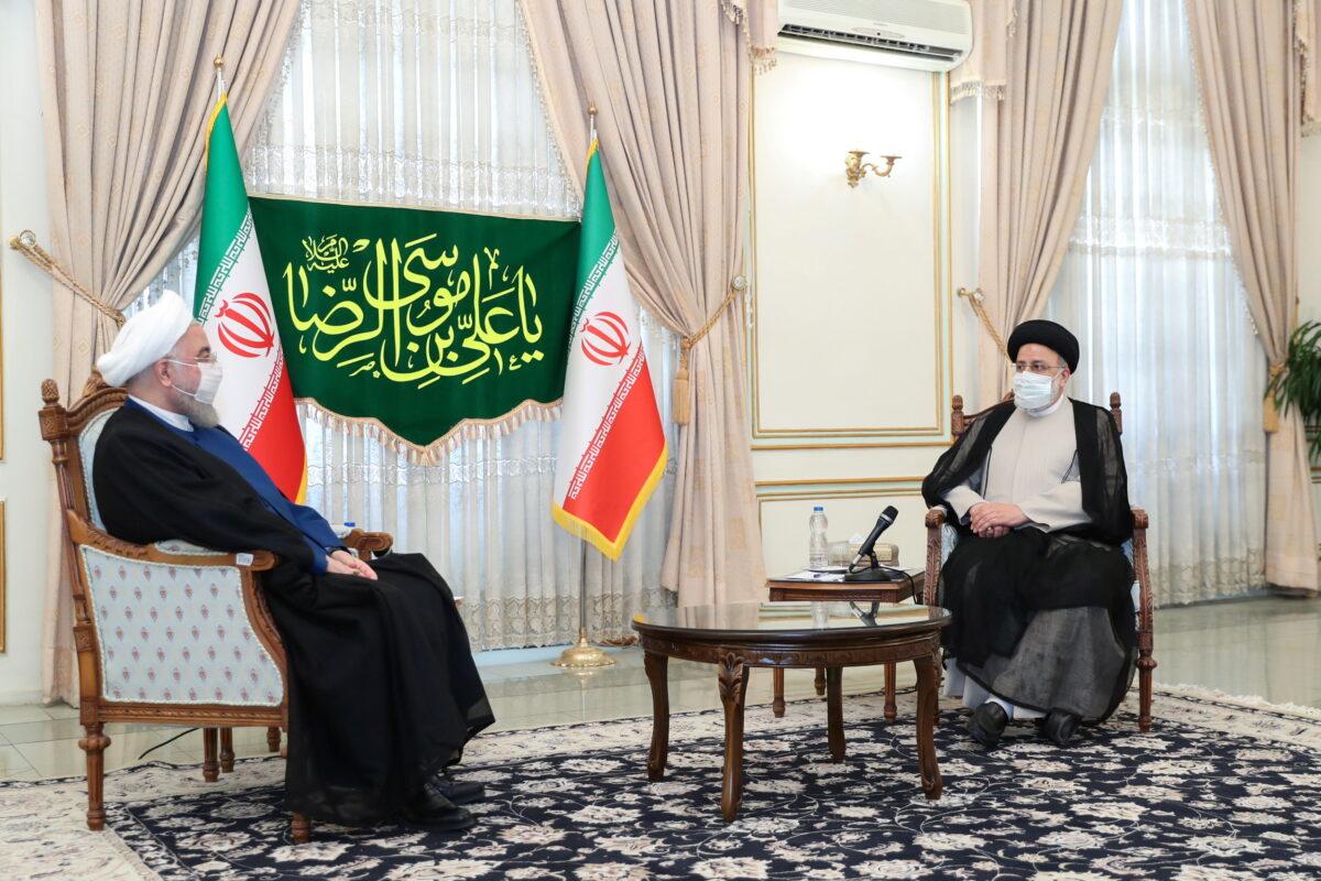 Iran's outgoing President Hassan Rouhani (L) meets with Iran's President-elect Ebrahim Raisi (R) in Tehran, Iran, on June 19, 2021. (Official Presidential website/Handout via Reuters)
