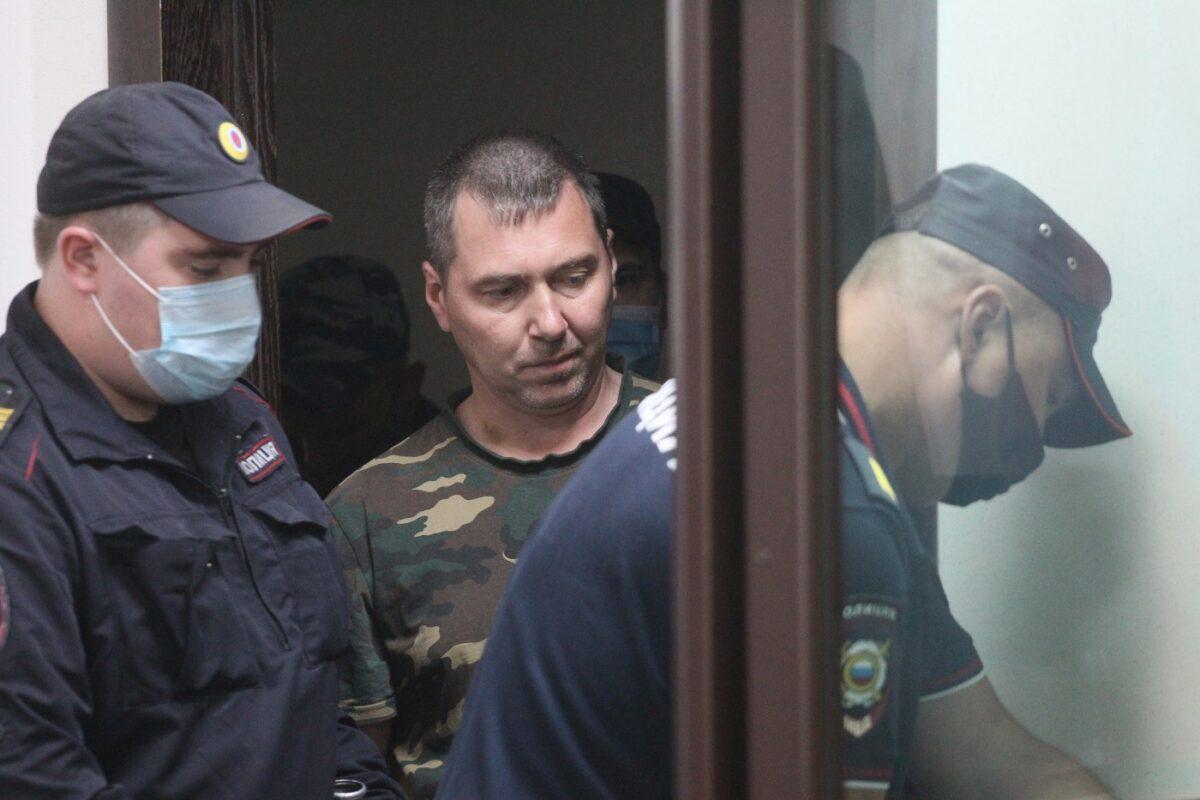 Alexander Popov, a man who was arrested on suspicion of murder and surrounded by police officers, arrives at a courtroom in the city of Gorodets, 36 miles north-west of Nizhny Novgorod, Russia, on June 20, 2021. (Roman Yarovitsyn/AP Photo)