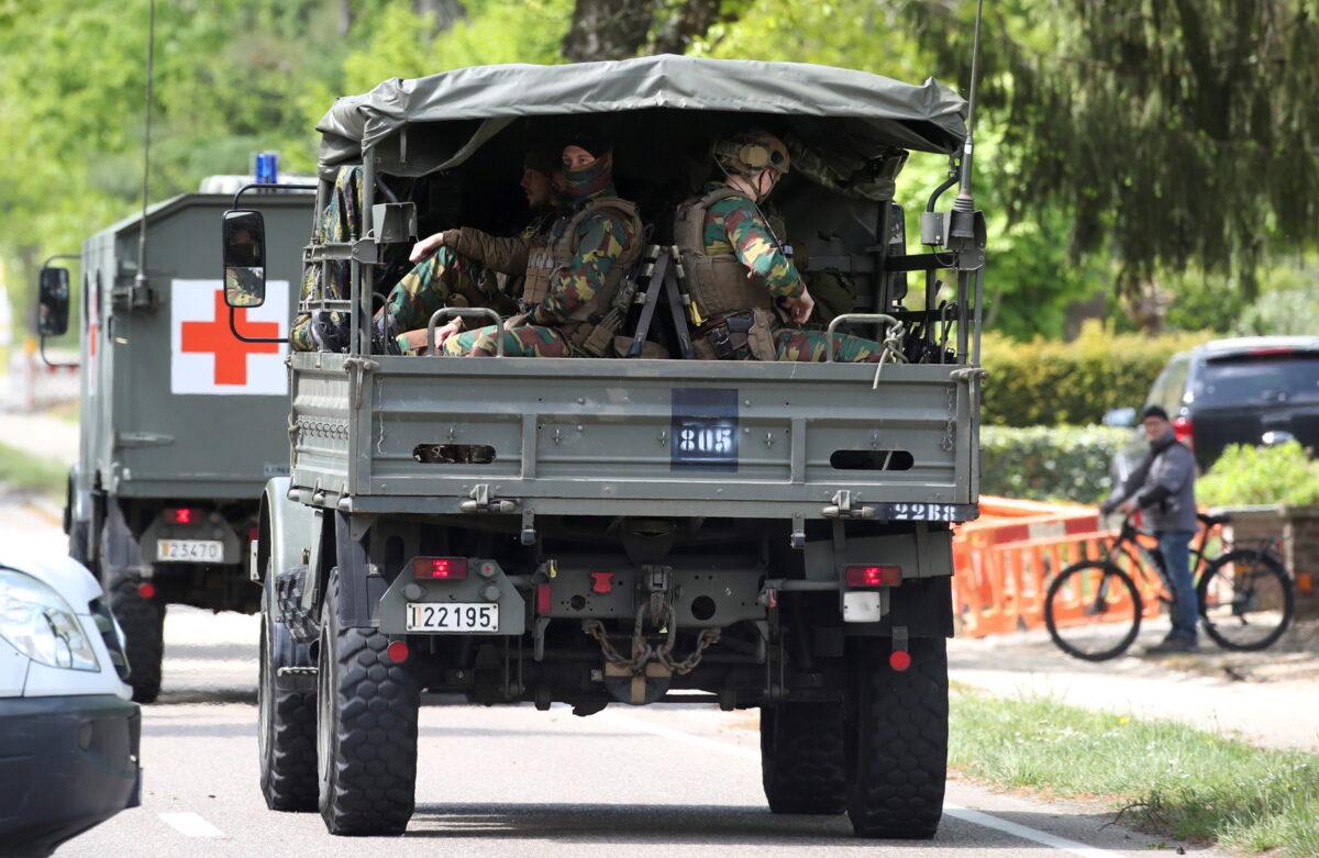 Belgian army ambulance and soldiers arrive at National Park Hoge Kempen while scouring to capture Belgian Jurgen Conings, a soldier who disappeared after threatening a virologist supportive of COVID-19 vaccines and coronavirus restrictions, in Maasmechelen, Belgium, on May 21, 2021. (Yves Herman/Reuters)