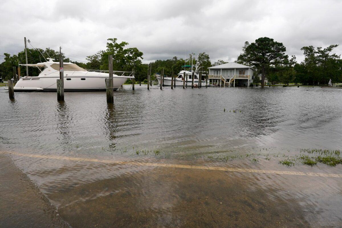 Drivers along the flooded Cedar Lake Road in Biloxi, Miss., found the road underwater and their cars almost parallel to the moored boats in the small harbor on June 19, 2021. (Rogelio V. Solis/AP Photo)