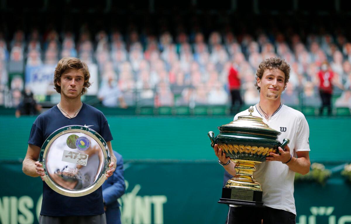 France's Ugo Humbert poses with trophy after winning the final against Russia's Andrey Rublev, who is posing with a runners up trophy at the ATP 500 Halle Open tennis tournament at the Gerry Weber Stadion, in Halle, Germany, on June 20, 2021. (Leon Kuegeler/Reuters)
