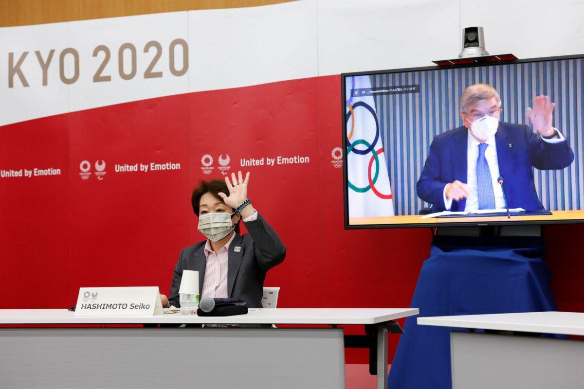 Tokyo 2020 President Seiko Hashimoto and IOC President Thomas Bach, on a screen, greet each other during a five-party online meeting at Harumi Island Triton Square Tower Y in Tokyo, on June 21, 2021. (Rodrigo Reyes Marin/Pool Photo via AP)