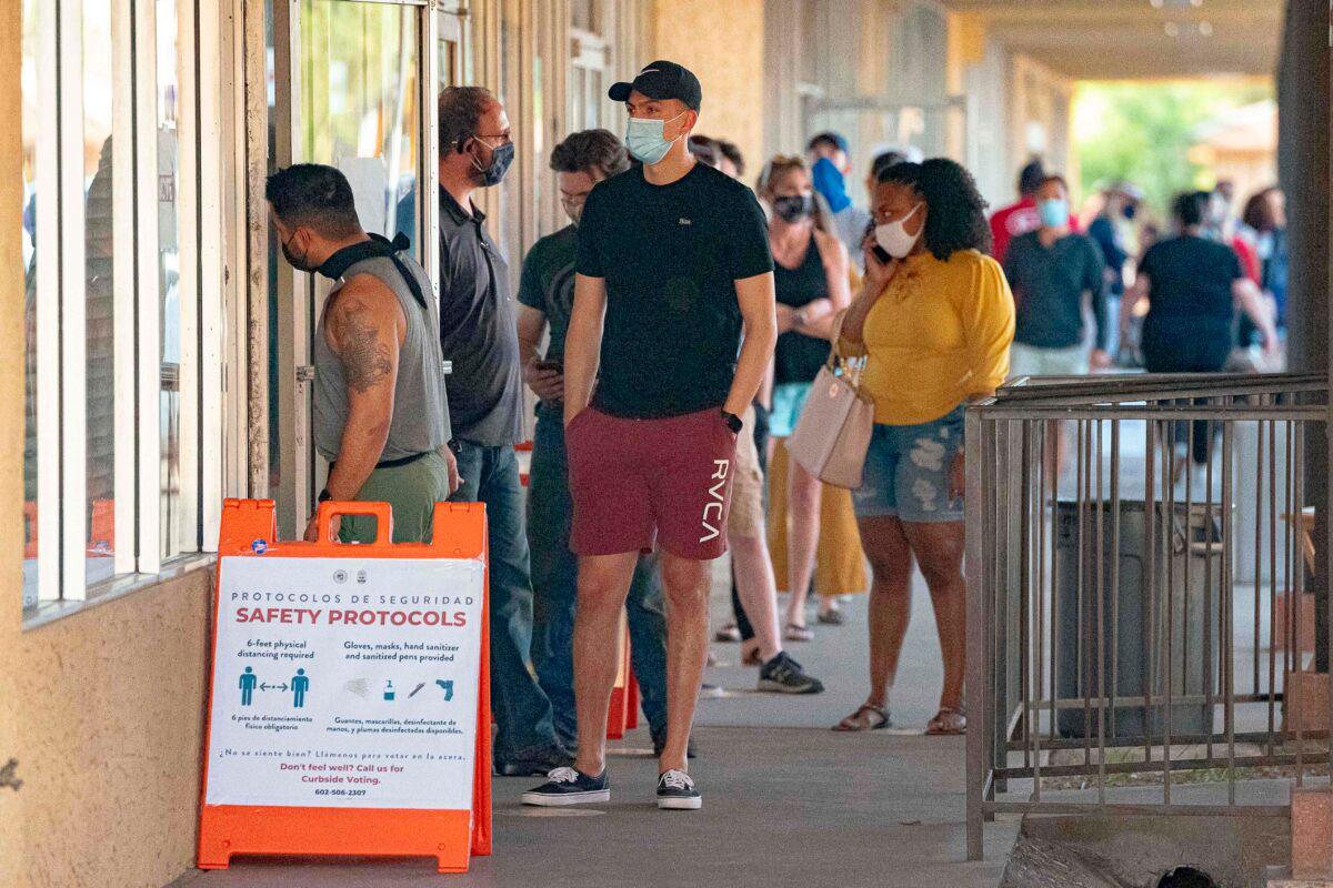 People wait in line to vote at a polling place at the Scottsdale Plaza Shopping Center, in Scottsdale, Ariz., on Nov. 3, 2020. (Olivier Touron/AFP via Getty Images)