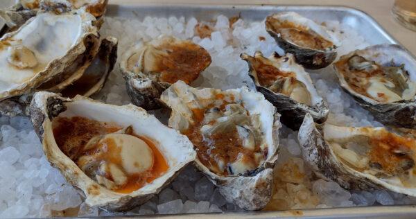 Fresh-grilled oysters in bubbling chipotle butter are popular offerings on the menu at FINCA Paso Robles. (Courtesy of Jim Farber)