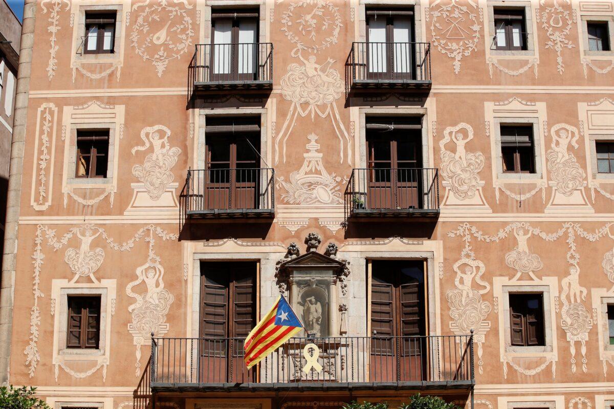 A yellow ribbon hangs from a balcony, next to an Estelada flag (Catalan separatist flag), in Barcelona, on June 22, 2021. (Albert Gea/Reuters)