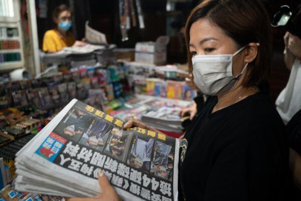 A woman buys multiple copies of the latest Apple Daily newspaper in Hong Kong on June 18, 2021. (Anthony Kwan/Getty Images)