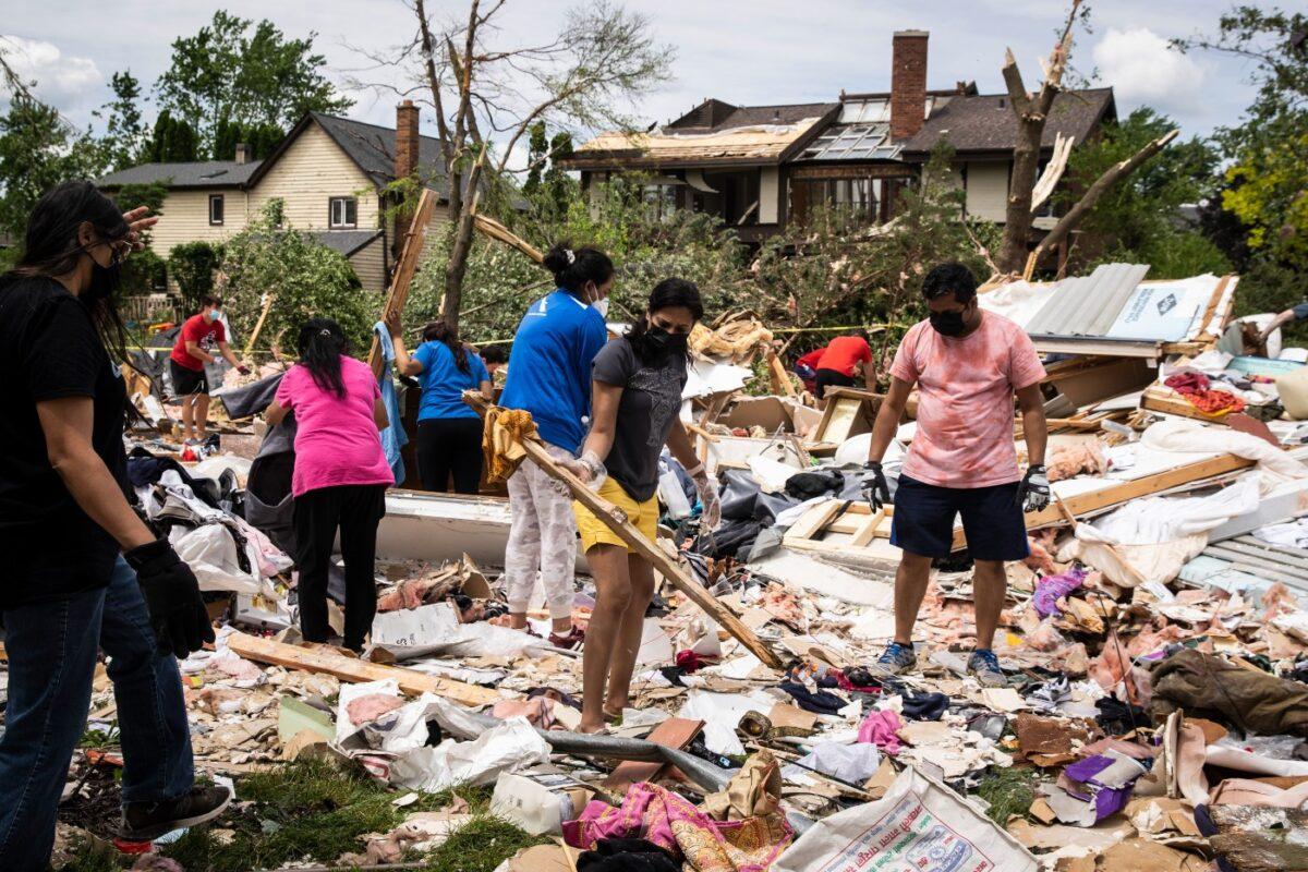 Dozens of volunteers help clean up a demolished home on Princeton Circle near Ranchview Drive in Naperville, Ill., after a tornado ripped through the western suburbs overnight, on June 21, 2021. (Ashlee Rezin Garcia/Sun-Times/Chicago Sun-Times via AP)