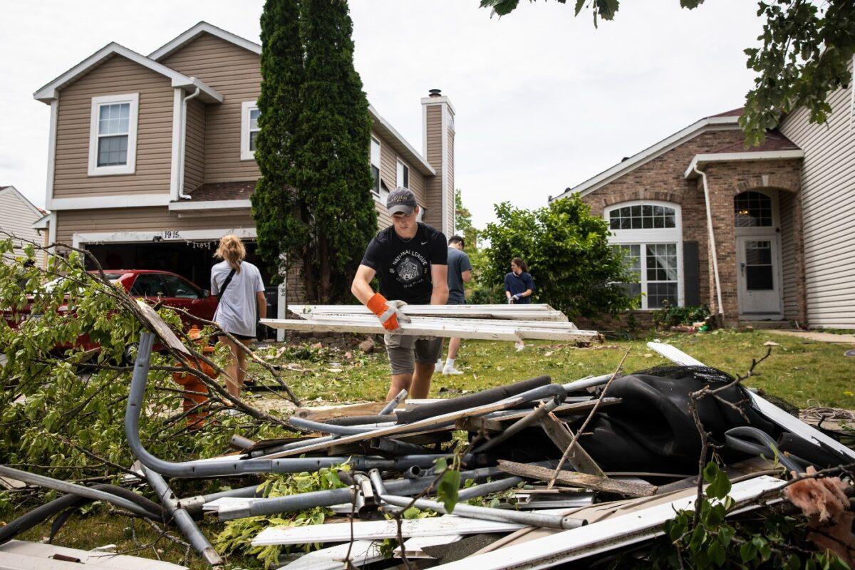 Dozens of volunteers help clean up damaged homes in Naperville, Ill., after a tornado ripped through the western suburbs overnight, on June 21, 2021. (Ashlee Rezin Garcia/Sun-Times/Chicago Sun-Times via AP)