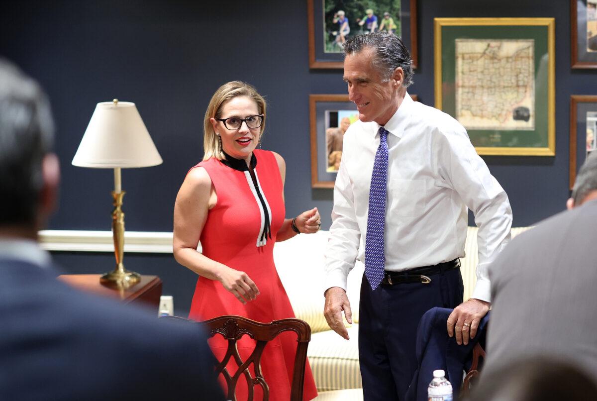 Sens. Kyrsten Sinema (D-Ariz.) (L) and Mitt Romney (R-Utah) arrive for a bipartisan meeting on infrastructure after original talks fell through with the White House in Washington on June 8, 2021. (Kevin Dietsch/Getty Images)