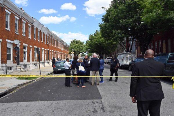 Baltimore Police Commissioner Michael Harrison, center, and Baltimore Mayor Brandon Scott, second from right, confer at the scene of a deadly shooting in Baltimore, Md. on June 16, 2021. (Kim Hairston/The Baltimore Sun via AP)