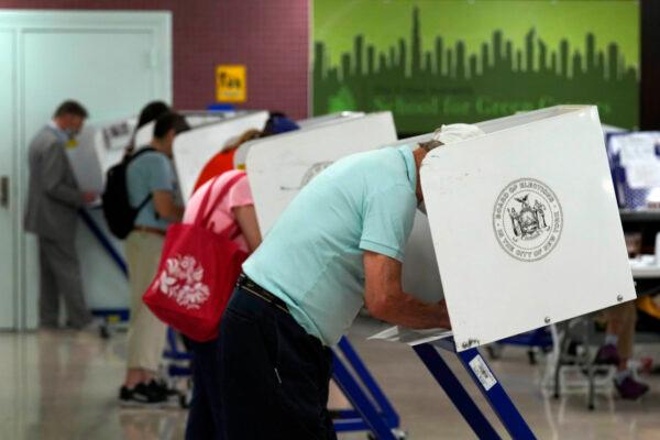 Voters mark their ballots at Frank McCourt High School, in New York, on June 22, 2021. (AP Photo/Richard Drew)