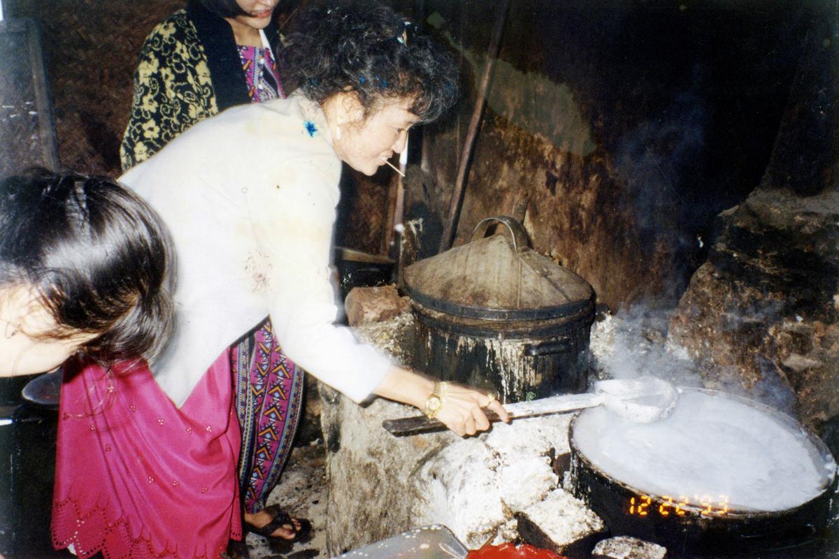 Tung Nguyen making pork rolling cakes, banh cuon, in Vietnam in 1993. The steamed rice paper rolls were Hy Vong's best-seller—and also the most difficult and labor-intensive dish at the restaurant, requiring practice and patience to create the delicate rice papers in a special Vietnamese steamer. (Courtesy of Chronicle Books)