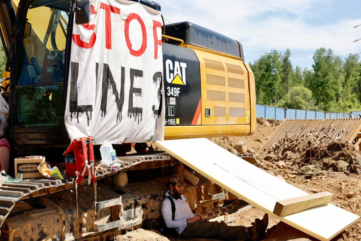 Environmental activists chain themselves to construction equipment at the Line 3 pipeline pumping station near Itasca State Park, Minn., on June 7, 2021. (Kerem Yucel/Getty Images)