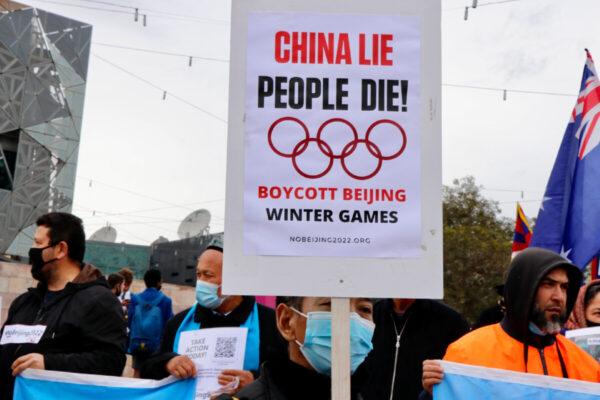 A protester holds up a panel at the "No Beijing 2022" rally in Melbourne, Australia, on June 23, 2021. (The Epoch Times)