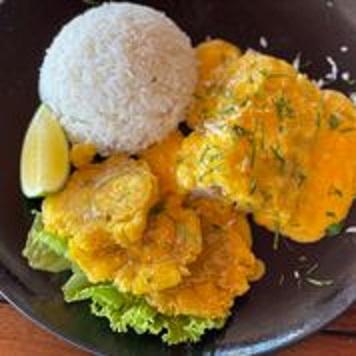 Ecuadorian pescado encocado, a traditional dish consisting of fish with coconut sauce and a side of fried ripe plantains. (Skye Sherman)