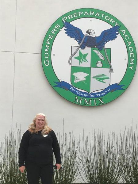 Kristie Chiscano stands next to the Gompers Preparatory Academy sign. (Courtesy Kristie Chiscano)