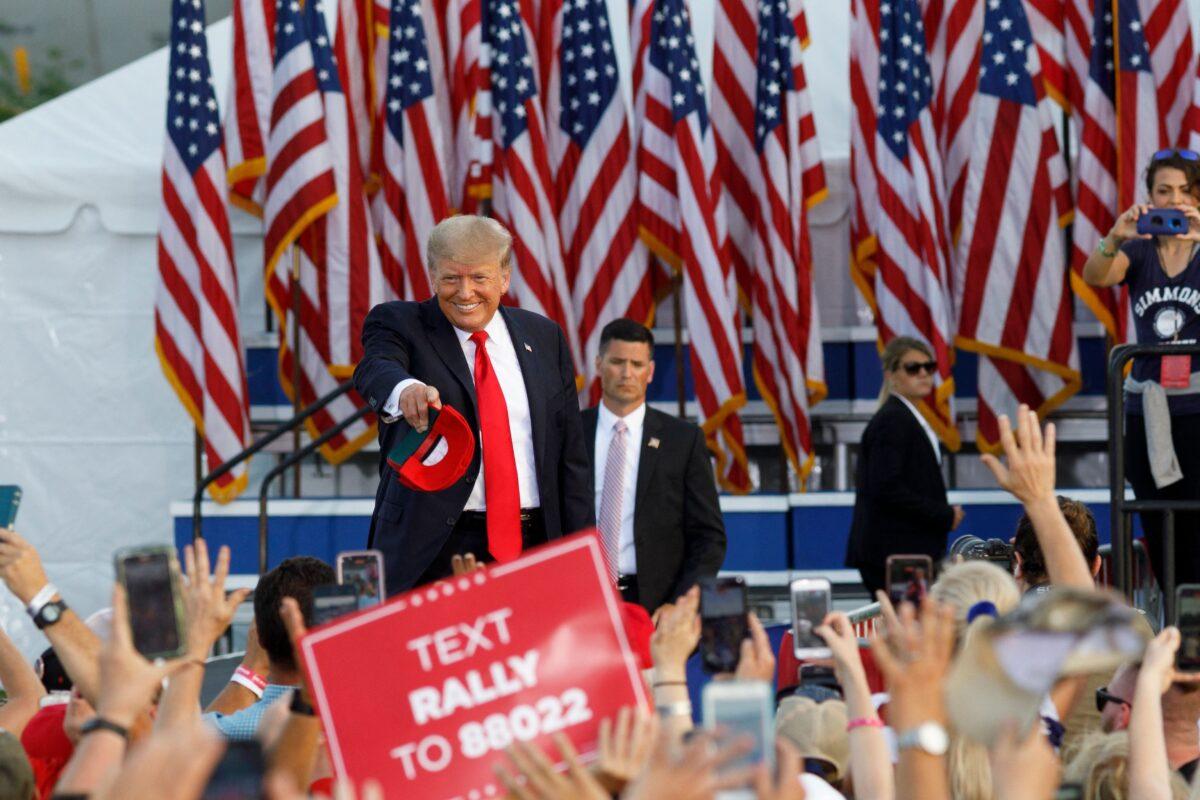 Former President Donald Trump points at individuals and throws hats into the crowd as he arrives for his campaign-style rally in Wellington, Ohio, on June 26, 2021. (Stephen Zenner/AFP via Getty Images)