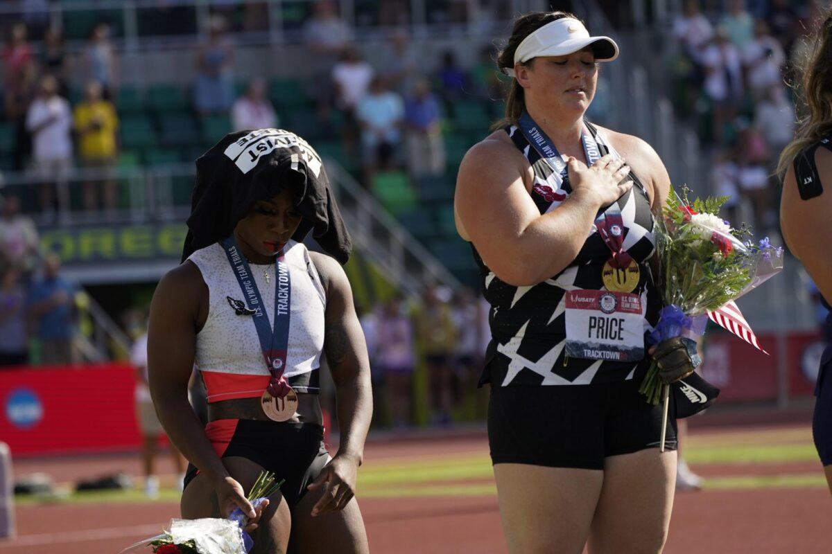 Gwendolyn Berry, left, drapes her Activist Athlete T-Shirt over her head as DeAnna Price stands for the national anthem after the finals of the women's hammer throw at the U.S. Olympic Track and Field Trials on June 26, 2021, in Eugene, Ore. (Charlie Riedel/AP Photo)