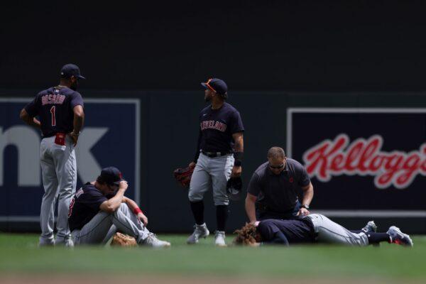 Cleveland Indians' Josh Naylor (22) lies on the ground with a member from the Indians medical staff after colliding with teammate in Minneapolis, Minn., on June 27, 2021. (Stacy Bengs/AP Photo)
